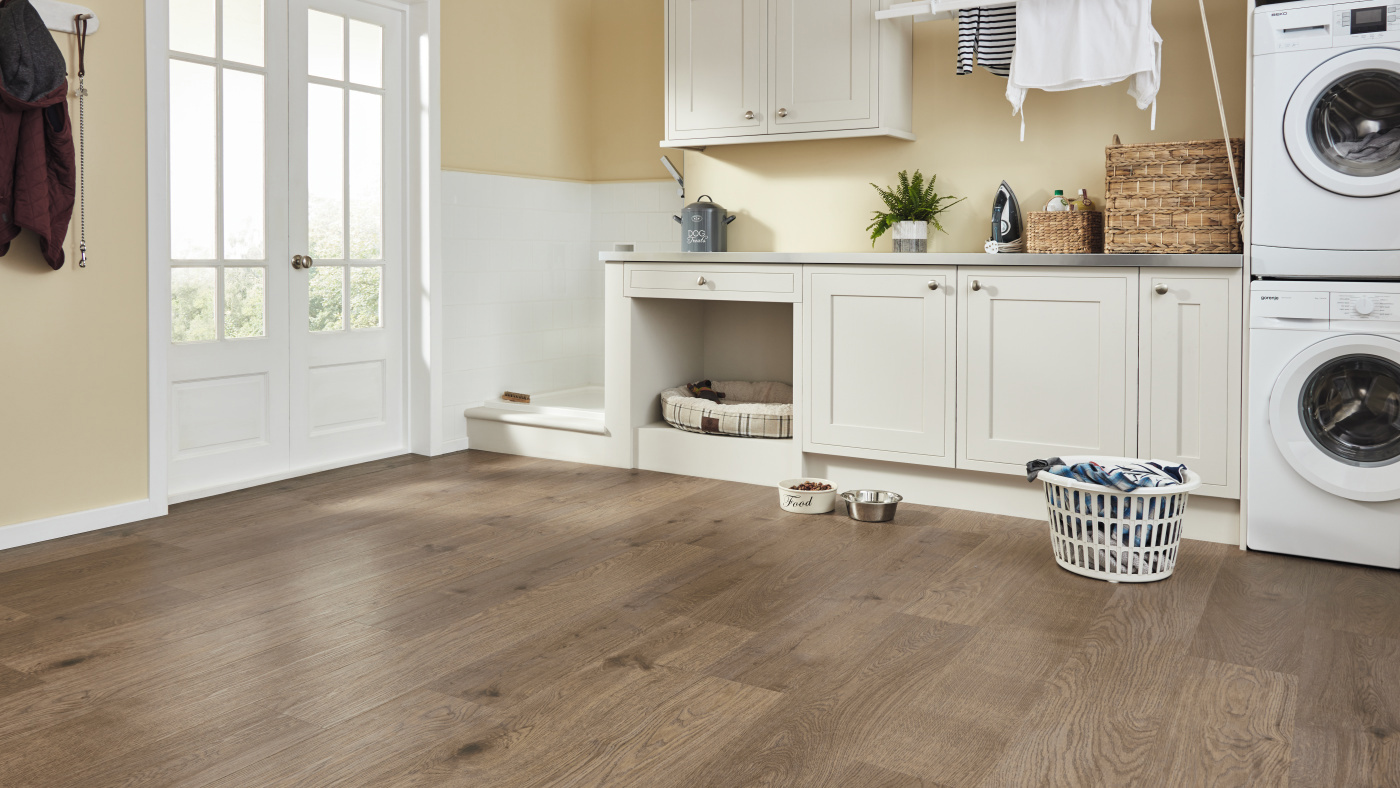 Dark brown plank flooring in a laundry / mud room